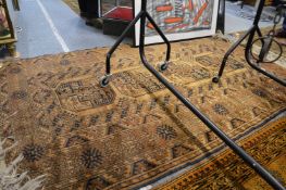 A gold ground Afghan rug.