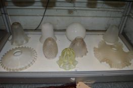 A collection of glass shades to include vaseline glass, cut class etc.