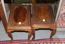 A pair of eastern carved wood hardwood occasional tables.