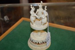 A carved group of elephants on a stand.