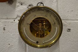 A circular brass barometer.