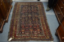 A Persian rug, blue ground with stylized decoration, worn.