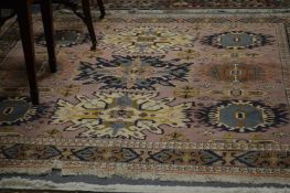 A Persian design carpet, puce ground with stylized decoration.