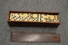 An old mahogany box of bone and ebony dominoes.