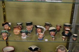 A group of small Royal Doulton character jugs and an ashtray.