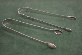 TWO GEORGE III BRIGHT CUT SUGAR TONGS, Circa.1800, maker T T & maker R C.