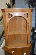 A small pine hanging corner shelf unit.