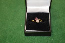 A gold ring set with a diamond and ruby.