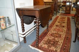 An oak drop-leaf dining table.