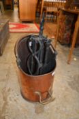 A copper coal scuttle and a companion set.