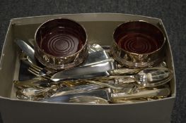 Plated cutlery and a pair of bottle coasters.