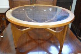 A mid-century teak and glass circular coffee table.