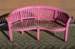 A pink painted hardwood garden bench.