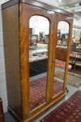 A Victorian mahogany two door wardrobe with mirrored doors and fitted interior.