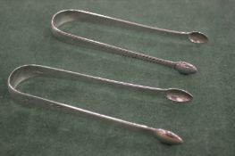 TWO GEORGE III BRIGHT CUT SUGAR TONGS, London circa.1800, maker R C & London 1792, maker T S.