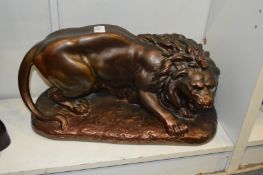 A bronzed plaster model of a lion.
