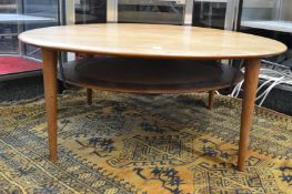 A good Danish teak circular two tier coffee table with rattan under tier designed by Peter Hvidt and