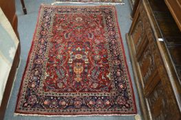 A Persian rug, claret ground with floral decoration.