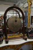 A Victorian ‘dinner gong’ mounted in a large carved oak arched shaped frame.