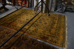 A gold ground Afghan rug.