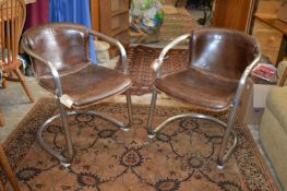 A pair of stylish steel framed and brown leather upholstered cantilever armchairs.