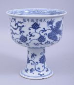 A CHINESE MING STYLE BLUE AND WHITE PORCELAIN STEM CUP, the exterior decorated with phoenix and