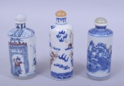 THREE CHINESE BLUE AND WHITE SNUFF BOTTLES, each with iron red decoration, two with marks, 10cm