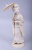 A JAPANESE MEIJI PERIOD CARVED IVORY OKIMONO - A GEISHA WITH PARASOL, signed to base, carved and