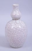 A CHINESE KANGXI PERIOD GUAN GLAZE DOUBLE GOURD PORCELAIN VASE, with a small museum repair to