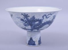 A CHINESE BLUE AND WHITE PORCELAIN STEM CUP, decorated with dragons upon waves, the interior