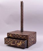 A JAPANESE WOOD AND LACQUER STAND, the base decorated with cranes and gilt latticework, the front