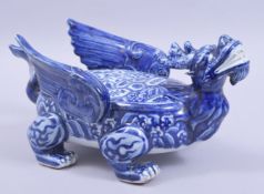 A CHINESE BLUE AND WHITE MING STYLE PORCELAIN BEAST, decorated with lotus and other flora, with