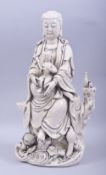 A LARGE CHINESE DEHUA PORCELAIN GUANYIN AND CHILD, seated upon a lotus stand, with marks to reverse,