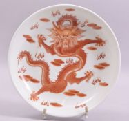 A CHINESE COPPER RED AND WHITE PORCELAIN DRAGON DISH, painted with a red dragon surrounded by