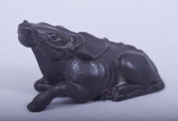A JAPANESE MEIJI PERIOD CARVED WOOD NETSUKE - RECUMBENT OXEN, the oxen laid pose, signed