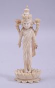 A 19TH CENTURY INDIAN CARVED IVORY MULTI ARMED GODDESS, stood upon lotus base, 13.5cm high.
