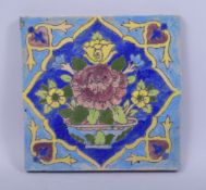 A PERSIAN POTTERY TILE, with floral decoration, 15.5cm square.