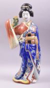 A JAPANESE ARITA PORCELAIN FIGURE, modelled as a geisha holding a fan, 46cm high.