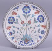 A TURKISH IZNIK POTTERY PLATE, decorated with foliate spray, 26.5cm diameter.