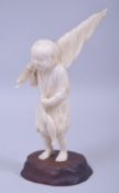 A JAPANESE MEIJI PERIOD CARVED IVORY OKIMONO - FISHERMAN, the boy stood holding his catch and net,