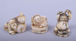 THREE JAPANESE MEIJI PERIOD CARVED IVORY NETSUKES, two signed, one of daruma, one of a man and gourd