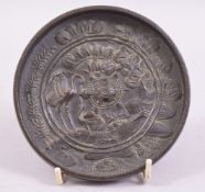 A JAPANESE BRONZE CIRCULAR HAND MIRROR, with raised decoration depicting stalks and a lily pond,