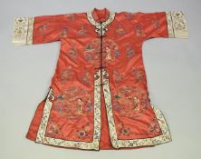 A CHINESE RED SILK ROBE, with embroidered decoration.