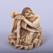 A JAPANESE MEIJI PERIOD CARVED IVORY NETSUKE - SEATED SENNIN, the sennin leaning upon his staff with