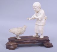 A JAPANESE MEIJI PERIOD CARVED IVORY OKIMONO GROUP - possibly tokyo school, depicting a young boy