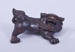 A SMALL CARVED WOOD FIGURE OF A LION DOG, 5.5cm wide.