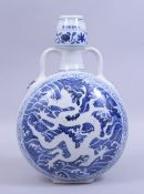 A CHINESE MING STYLE BLUE AND WHITE TWIN HANDLE PORCELAIN MOONFLASK, painted with a white dragon