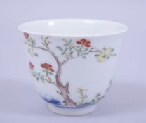 A CHINESE PORCELAIN TEA CUP, decorated with a tree, the reverse with calligraphy, six character mark
