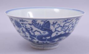 A CHINESE BLUE AND WHITE PORCELAIN BOWL, the exterior painted with dragons amongst scrolling foliate