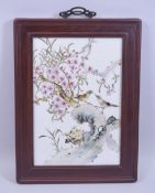 A CHINESE POLYCHROME PORCELAIN PANEL WITH HARDWOOD FRAME, the panel depicting birds and native